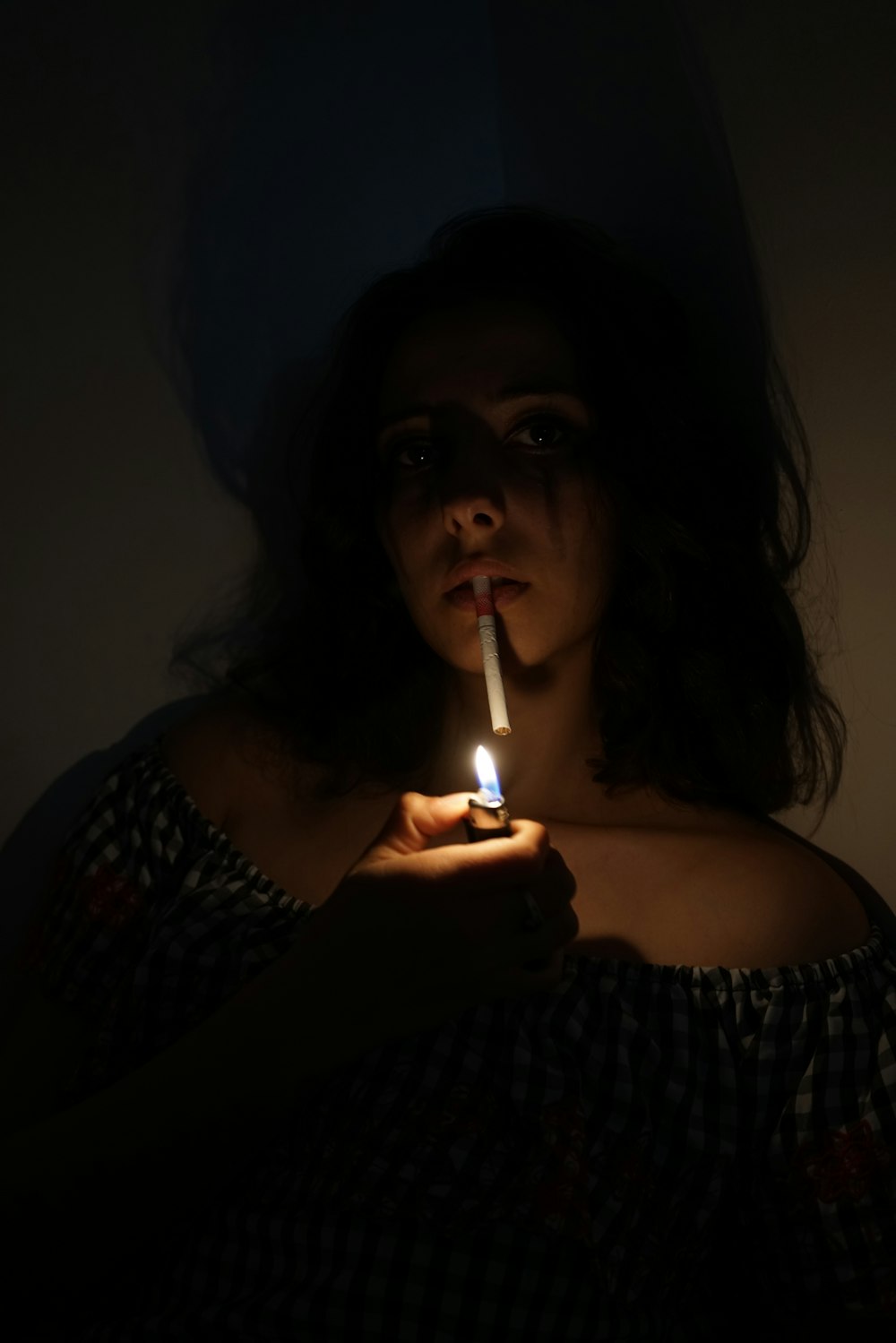 woman in black and white shirt smoking