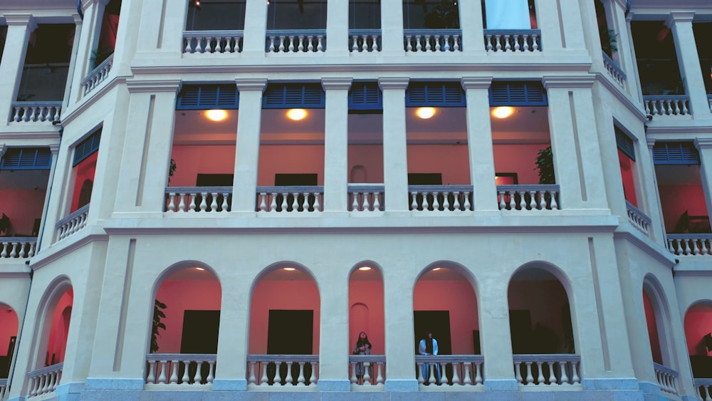 pessoas andando em um edifício de concreto branco e vermelho durante o dia