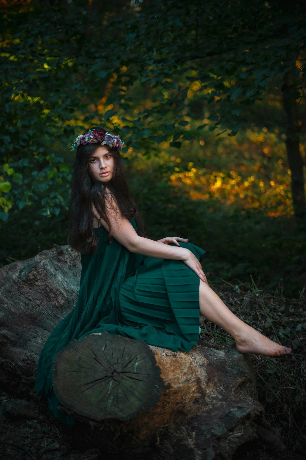 woman in green dress sitting on rock