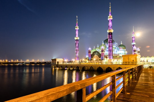 green and brown concrete building near body of water during night time in Terengganu Malaysia