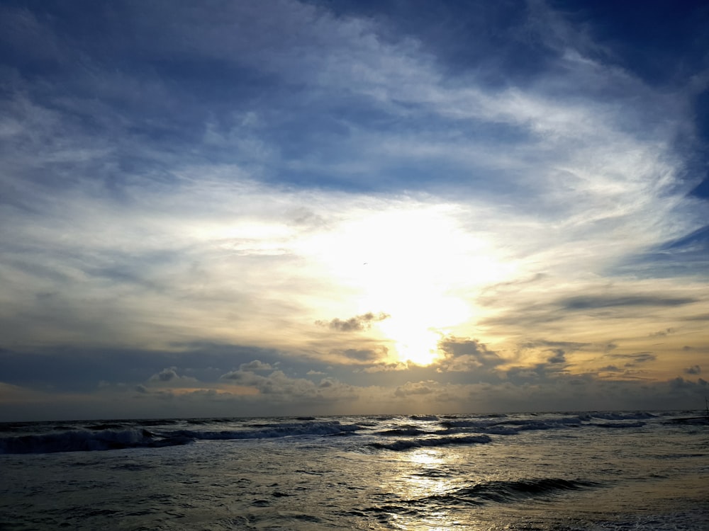 body of water under cloudy sky during daytime