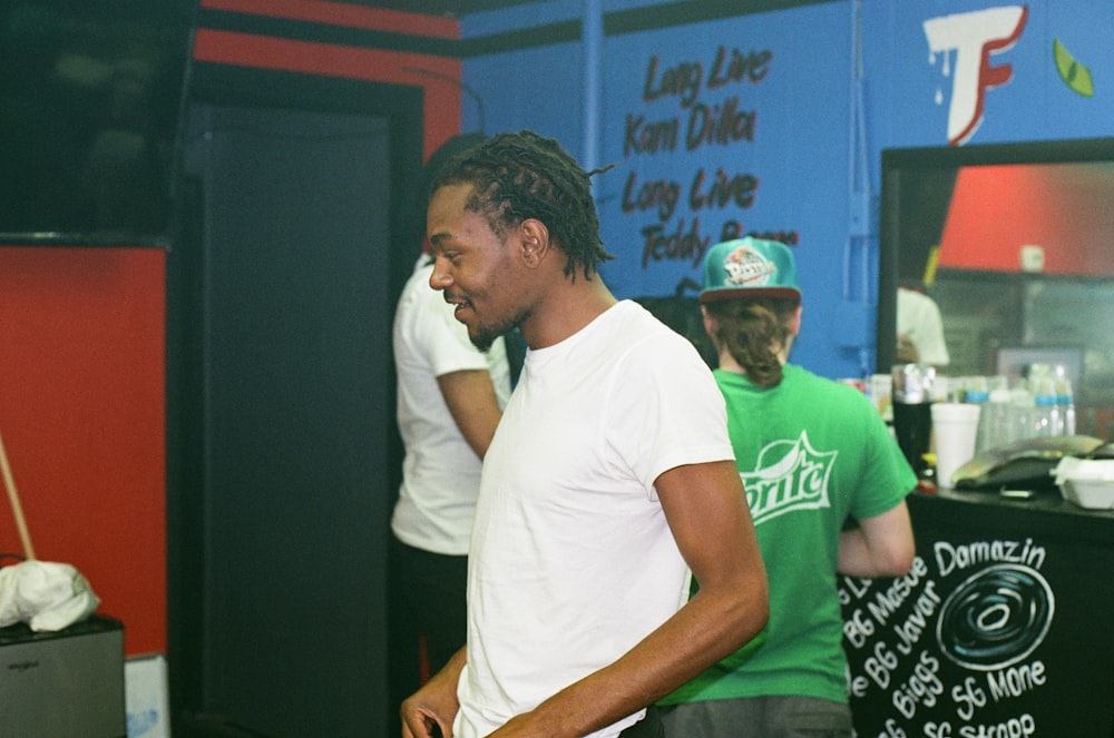 man in white crew neck t-shirt sitting beside man in green t-shirt