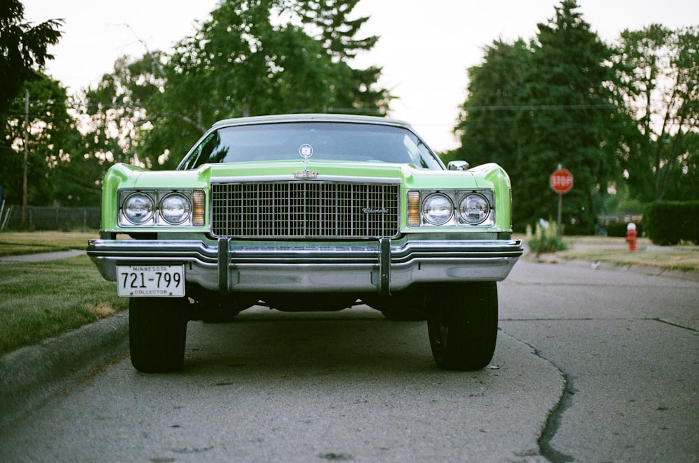 green car parked on the side of the road during daytime