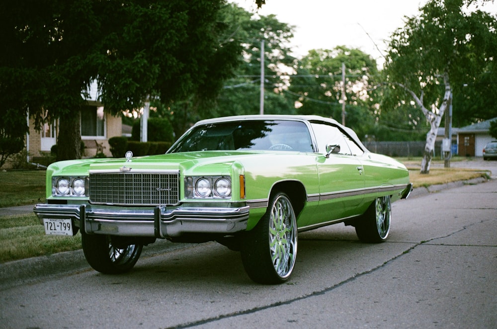 green classic car parked on the side of the road during daytime