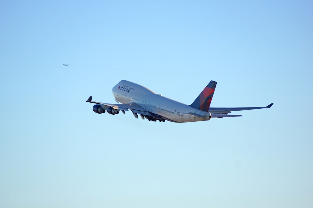 white passenger plane in mid air during daytime,