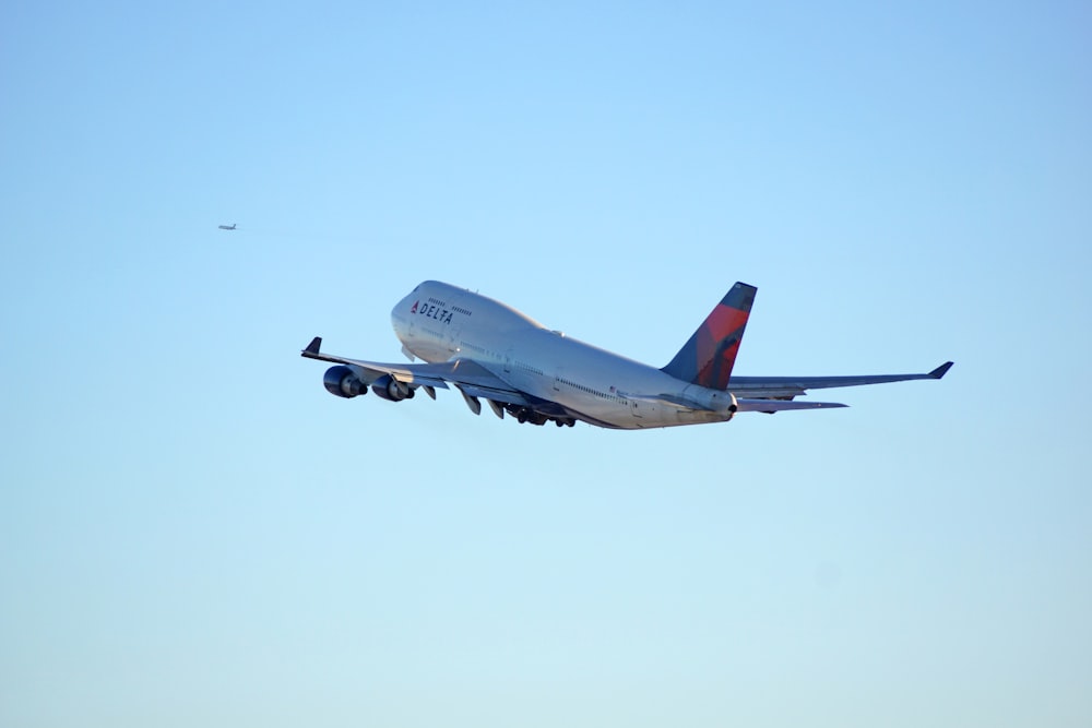 white passenger plane in mid air during daytime