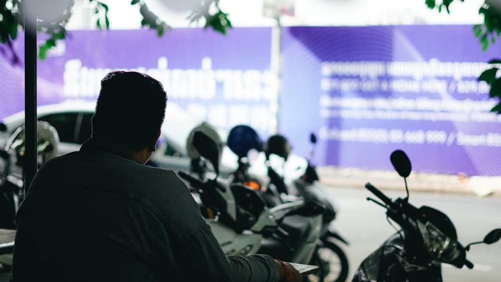 man in black suit jacket sitting on motorcycle