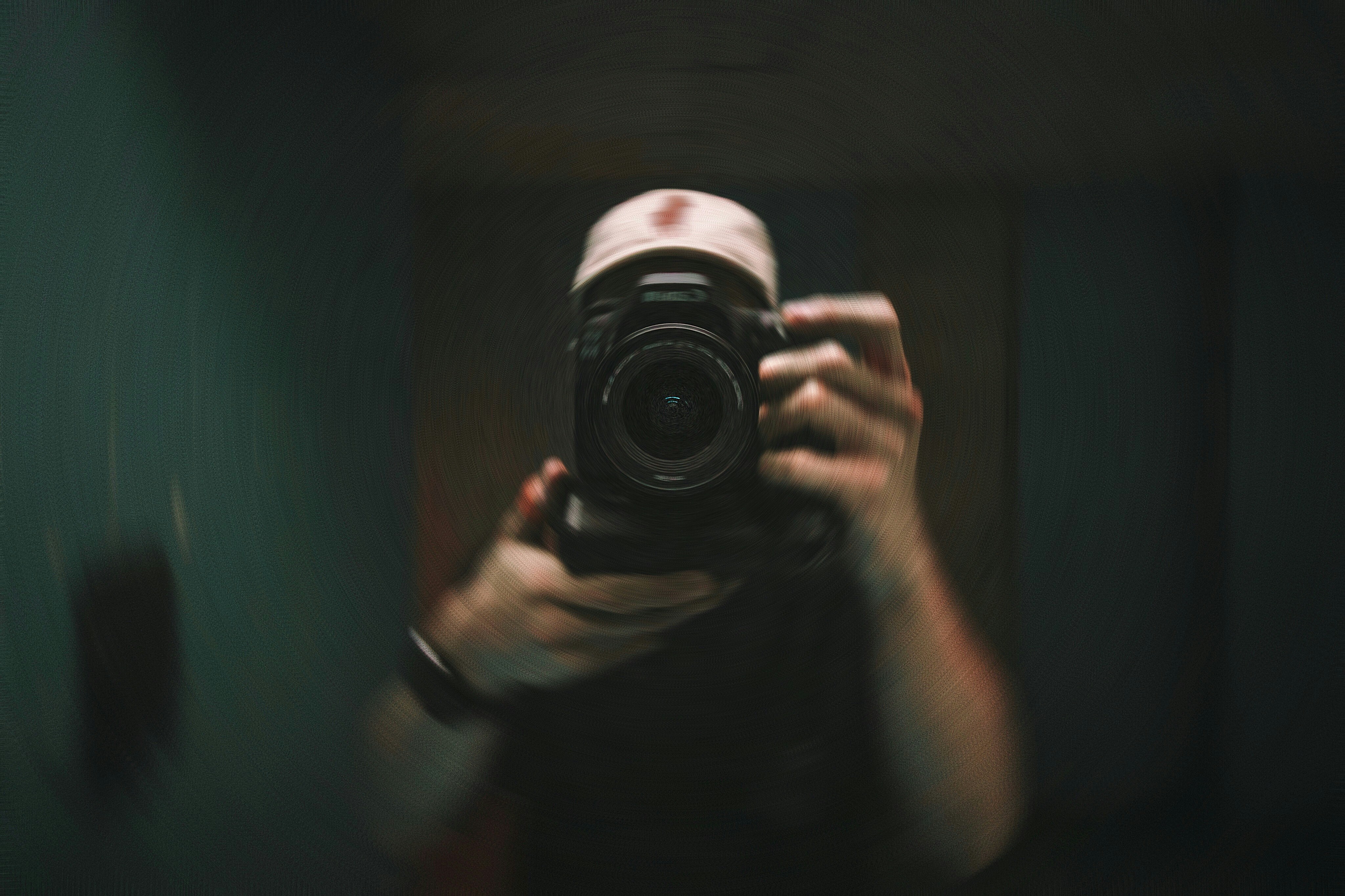 person holding black and silver camera