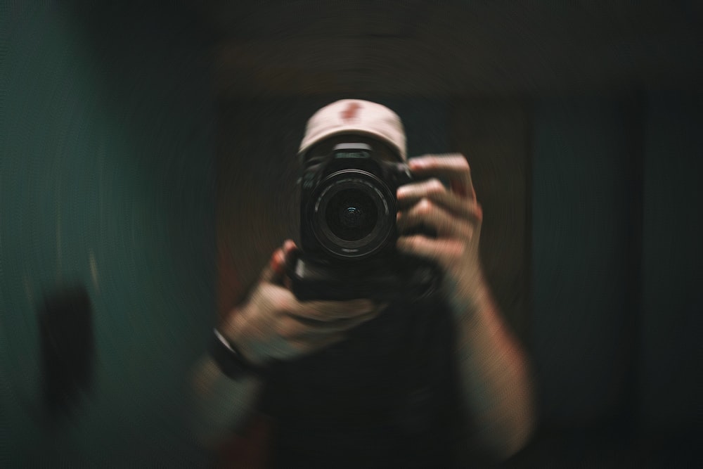 person holding black and silver camera