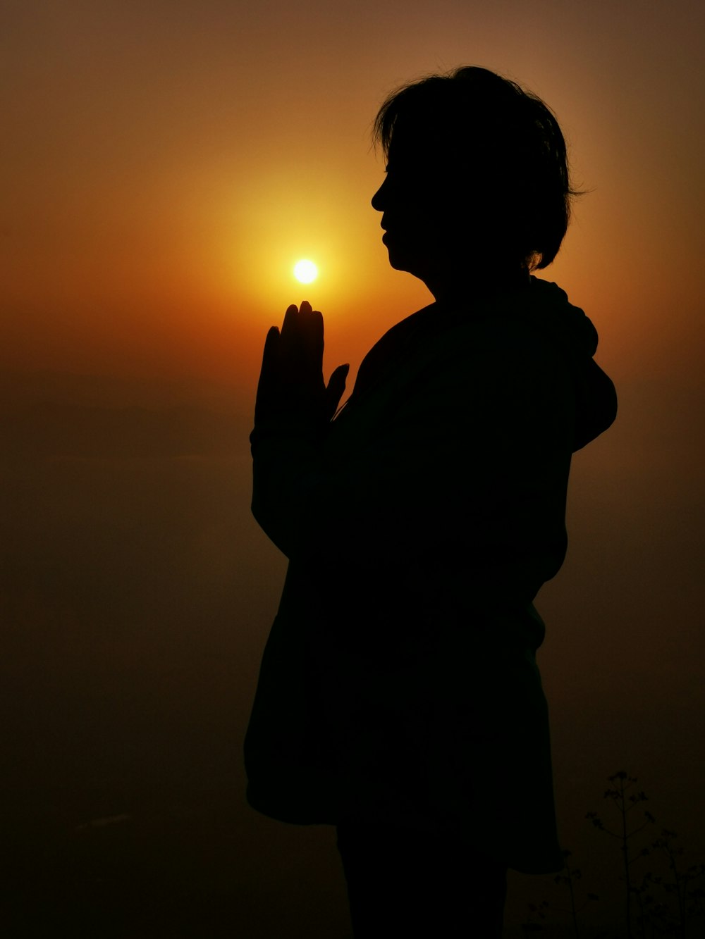 silhouette of woman holding sun