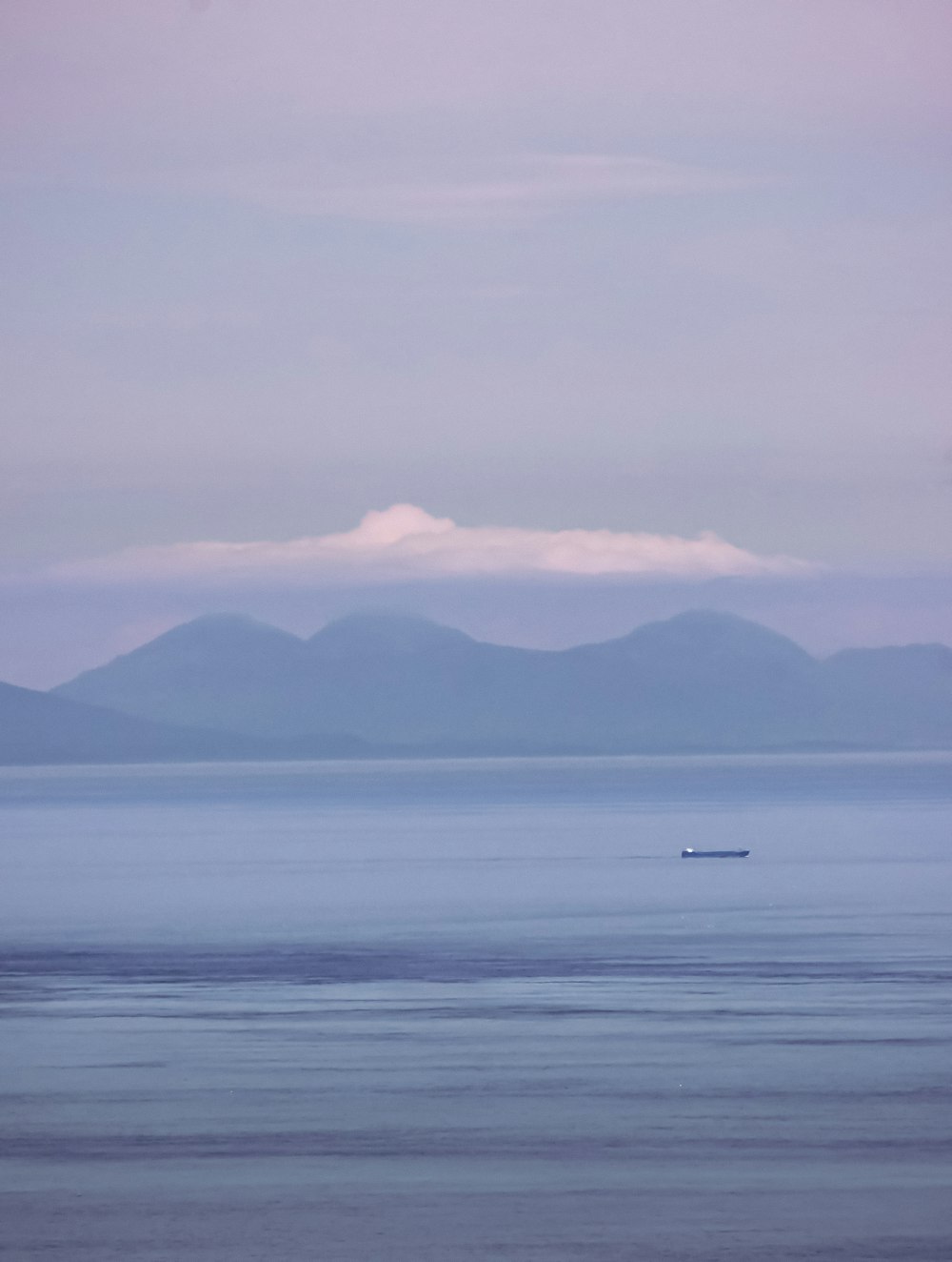 boat on sea near mountain during daytime