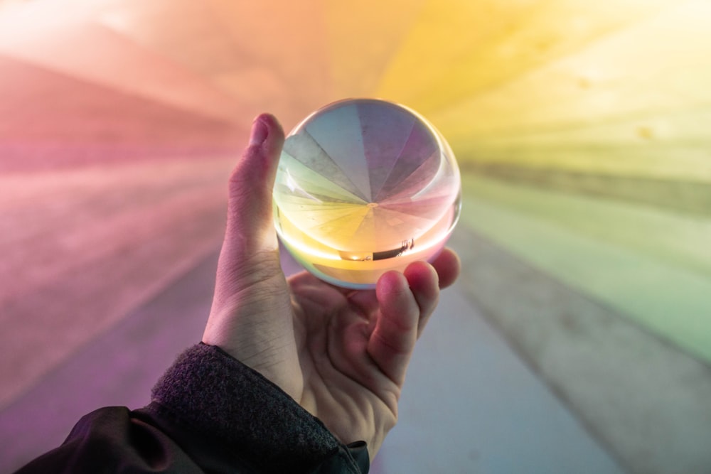 person holding clear glass ball