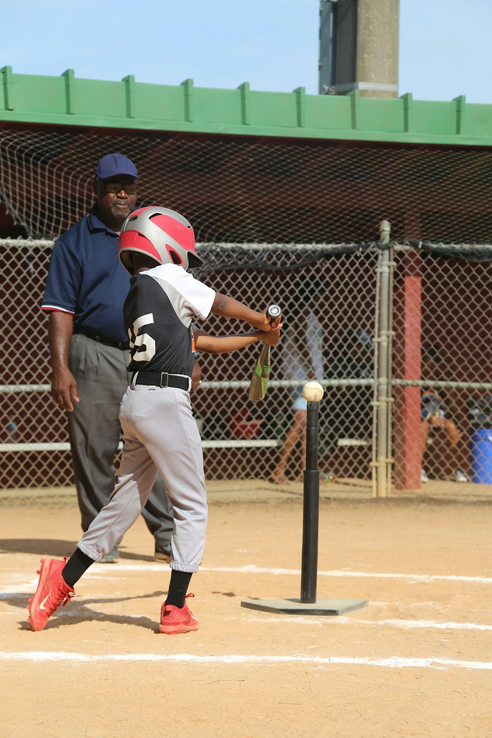 man in black and white jersey shirt and white pants holding baseball bat