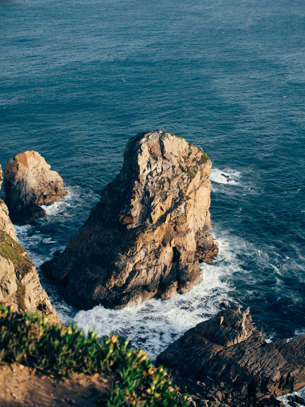 brown rock formation beside blue sea during daytime