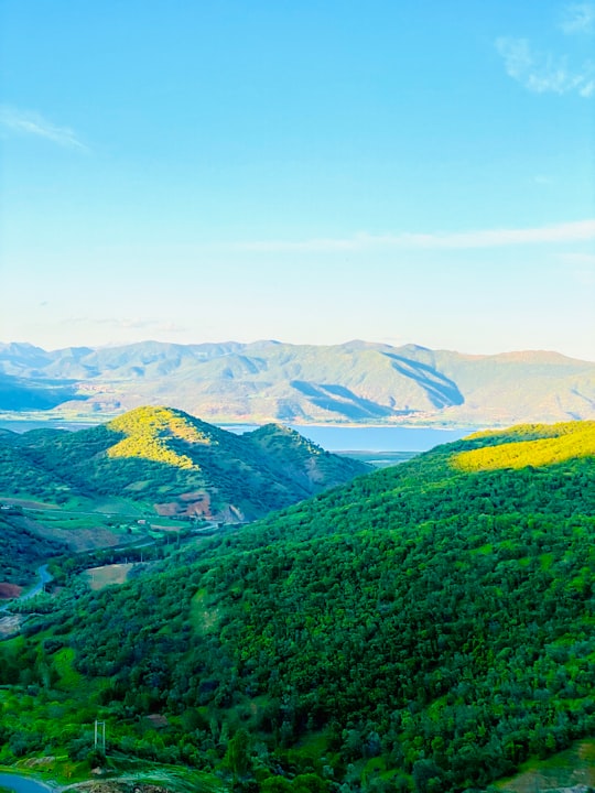 green grass field and mountains during daytime in Kurdistan Iran