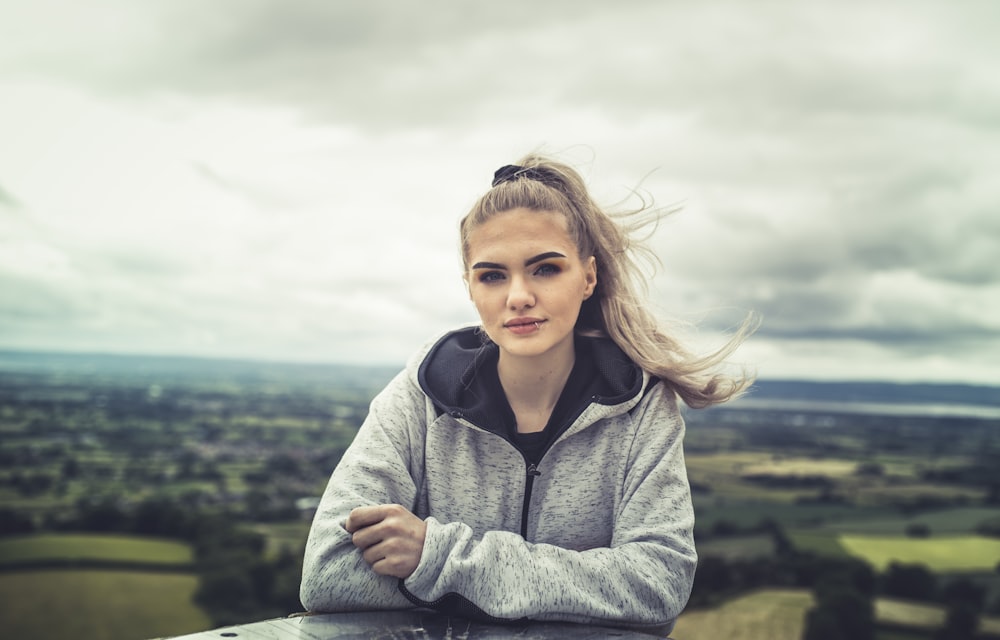 girl in gray hoodie standing on green grass field during daytime