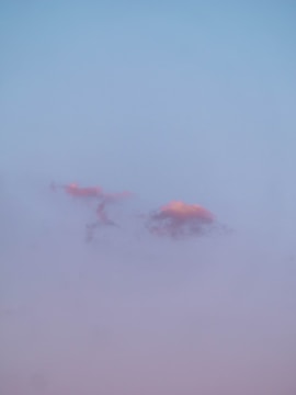 A delicate illustration of a serene person gently floating among clouds with pastel colors.