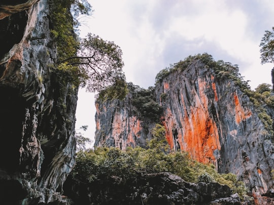 brown and green rocky mountain under white cloudy sky during daytime in Ao Phang-nga National Park Thailand