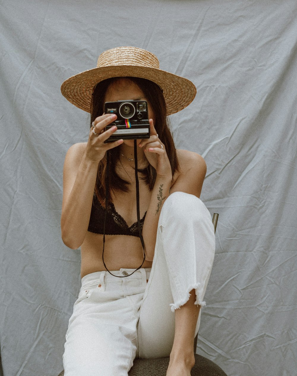 woman in white long sleeve shirt holding black and silver camera