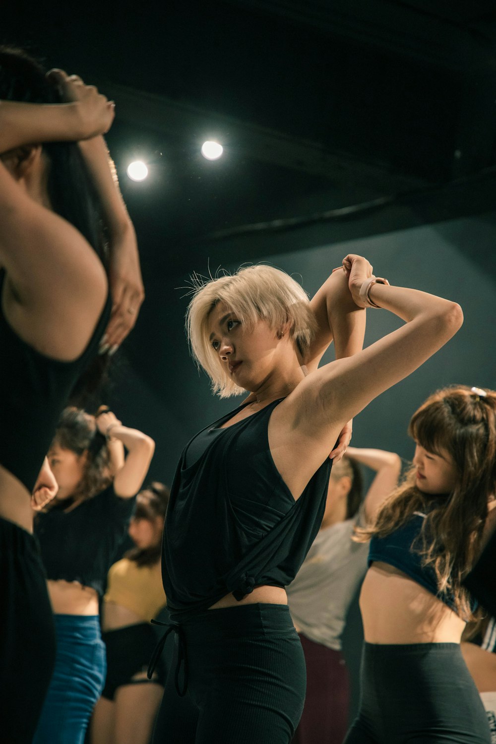 woman in black tank top raising her hands