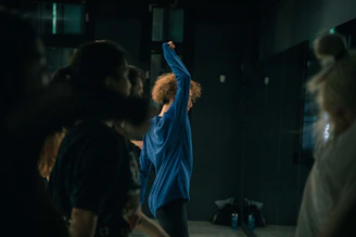 man in blue shirt standing in front of people