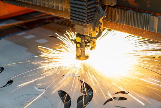 Close-up of laser cutting machine in action, showing precise cutting on metal sheets.