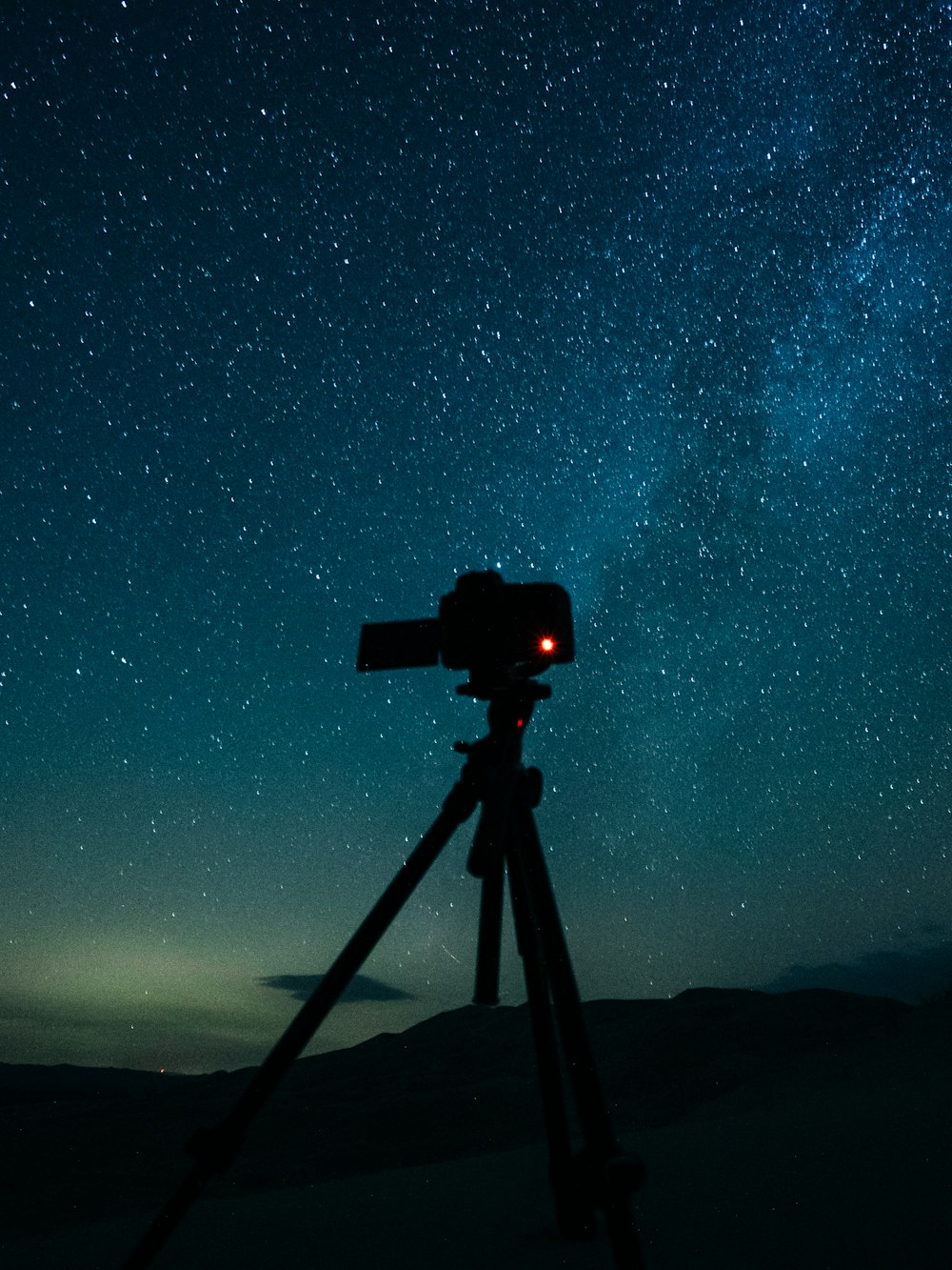 black camera on tripod under starry night