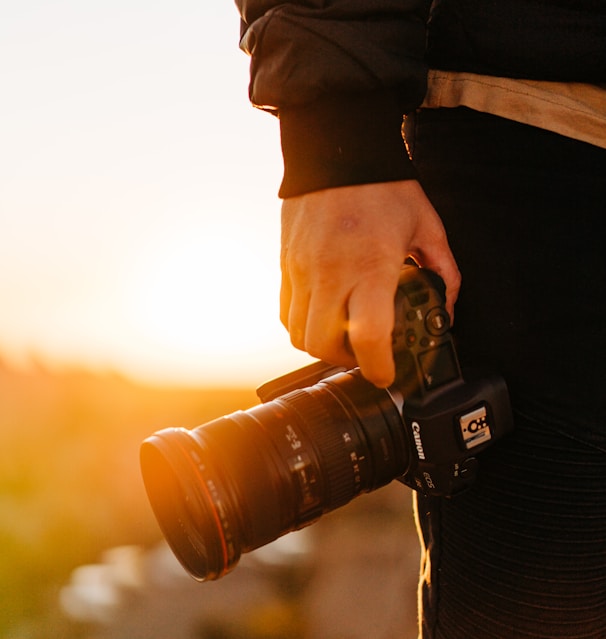 person holding black dslr camera