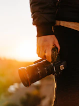 A warm candid photo of me laughing with a camera in hand during golden hour