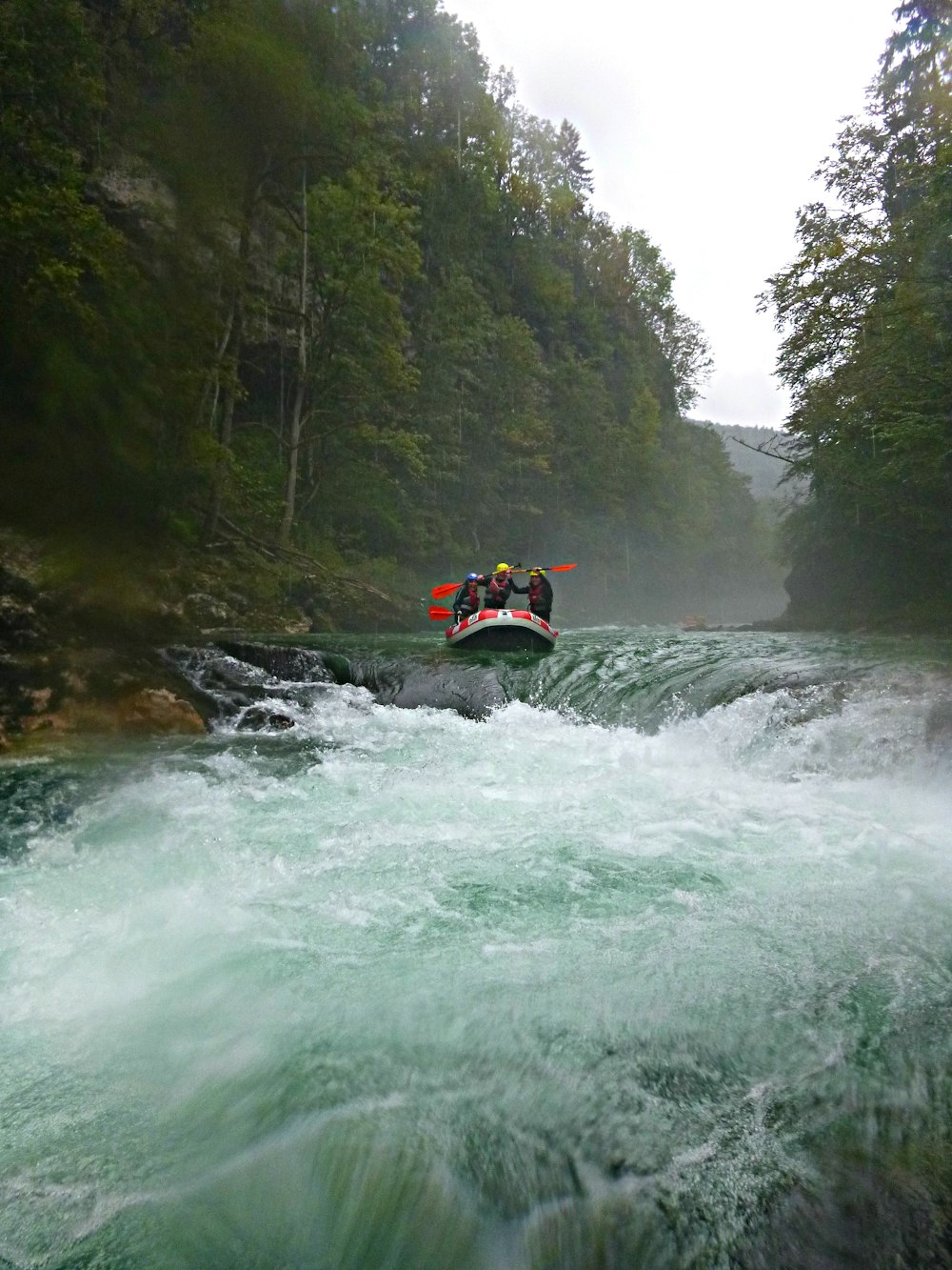 Persona che cavalca il kayak arancione sul fiume durante il giorno