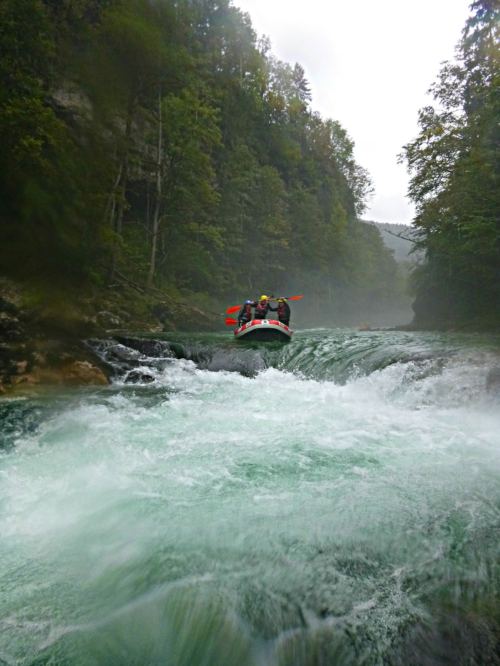 Person, die tagsüber mit einem orangefarbenen Kajak auf dem Fluss fährt