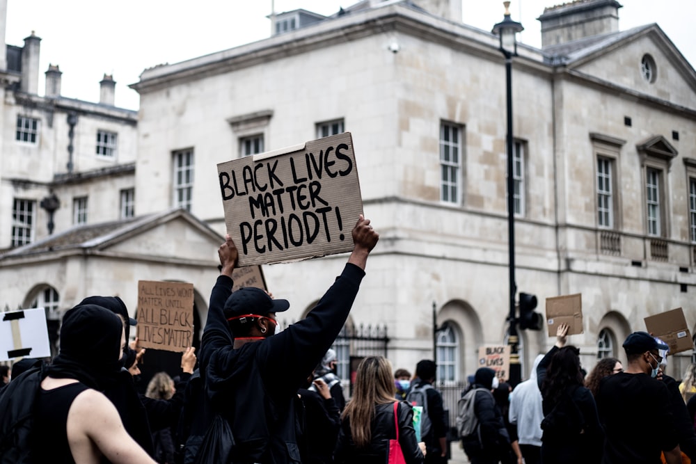 people holding white and black printed paper