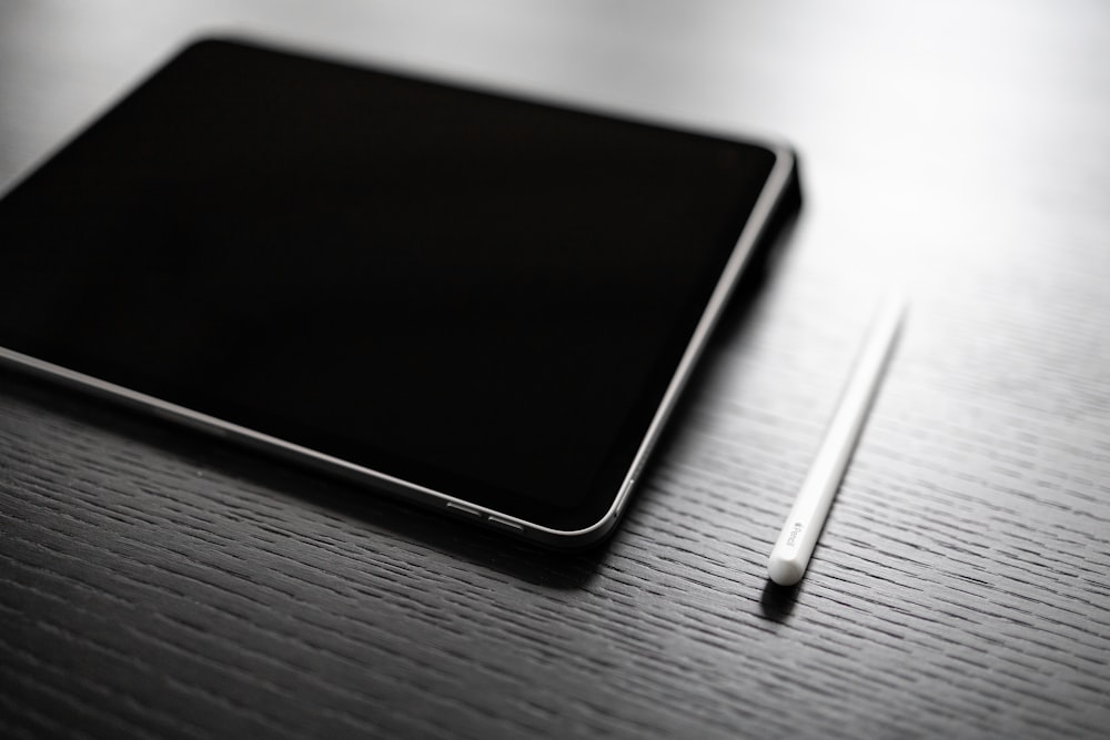 black tablet computer on brown wooden table