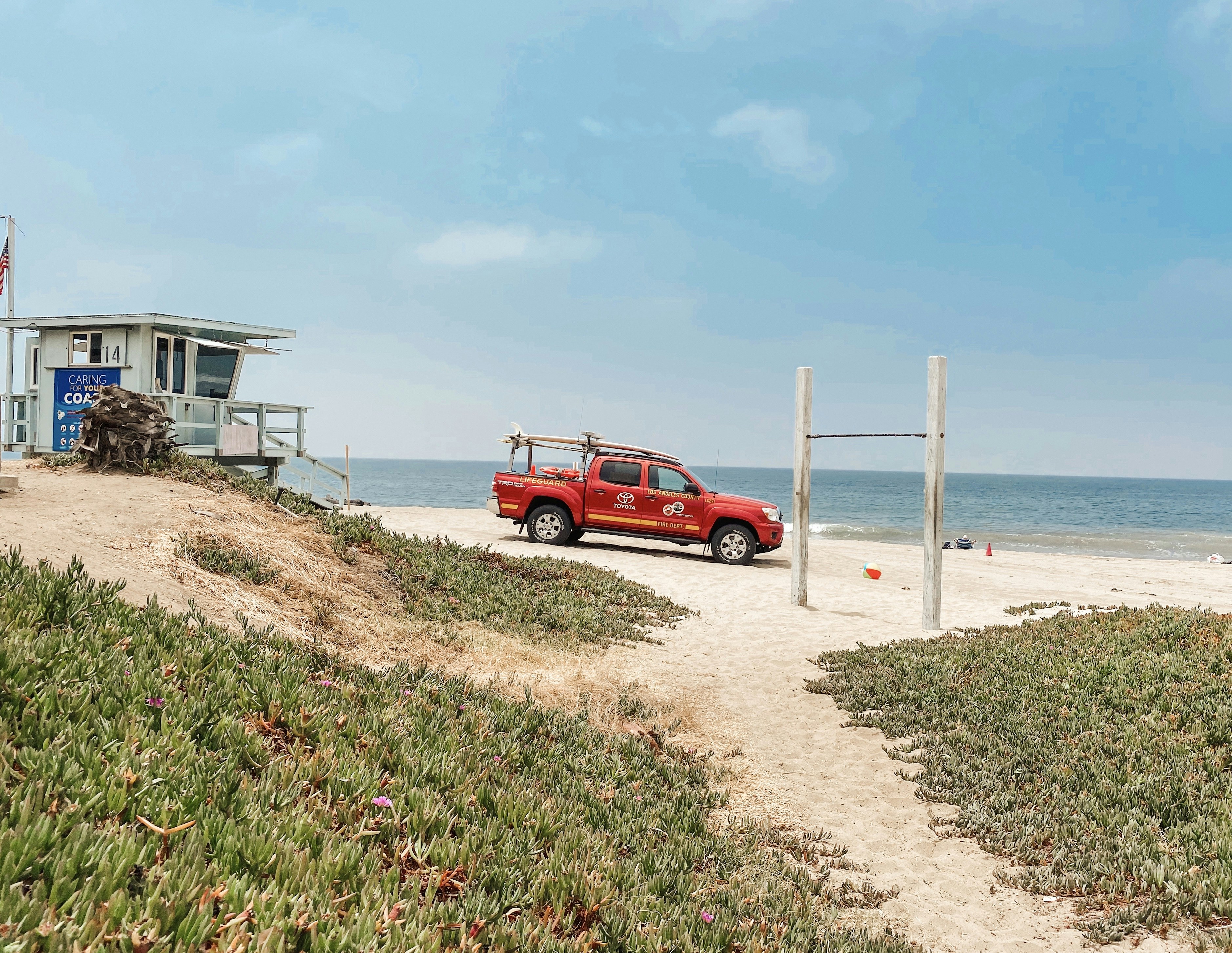 SUV rojo en la orilla de la playa durante el día