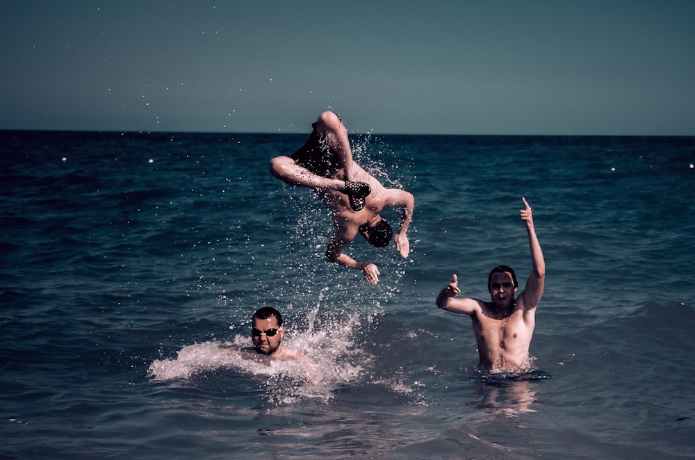 a group of people in the water playing with a frisbee