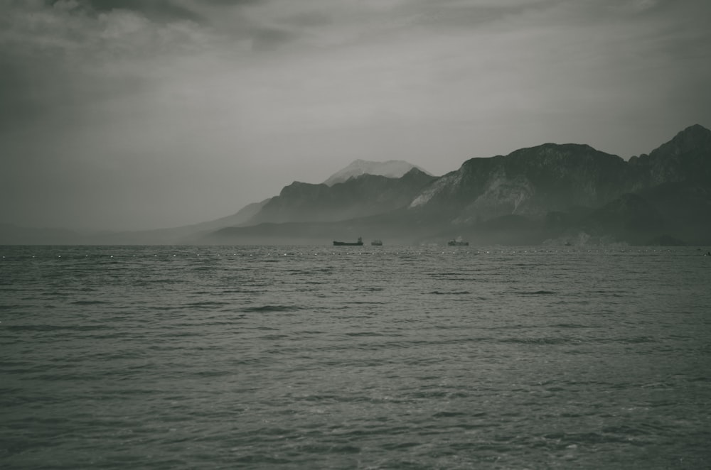 body of water near mountain during daytime