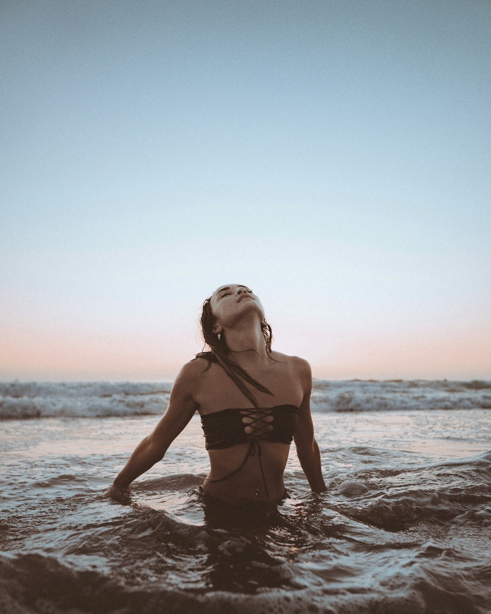 woman in black bikini standing on beach during daytime