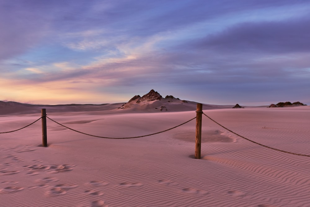 brown wooden post on brown sand during sunset