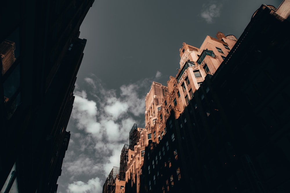 low angle photography of high rise buildings under cloudy sky