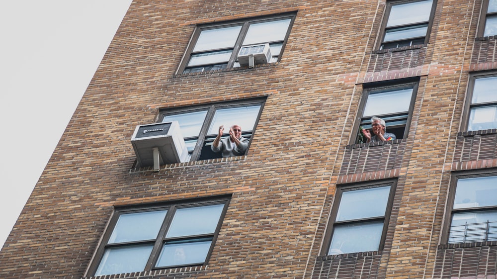 man and woman sitting on window