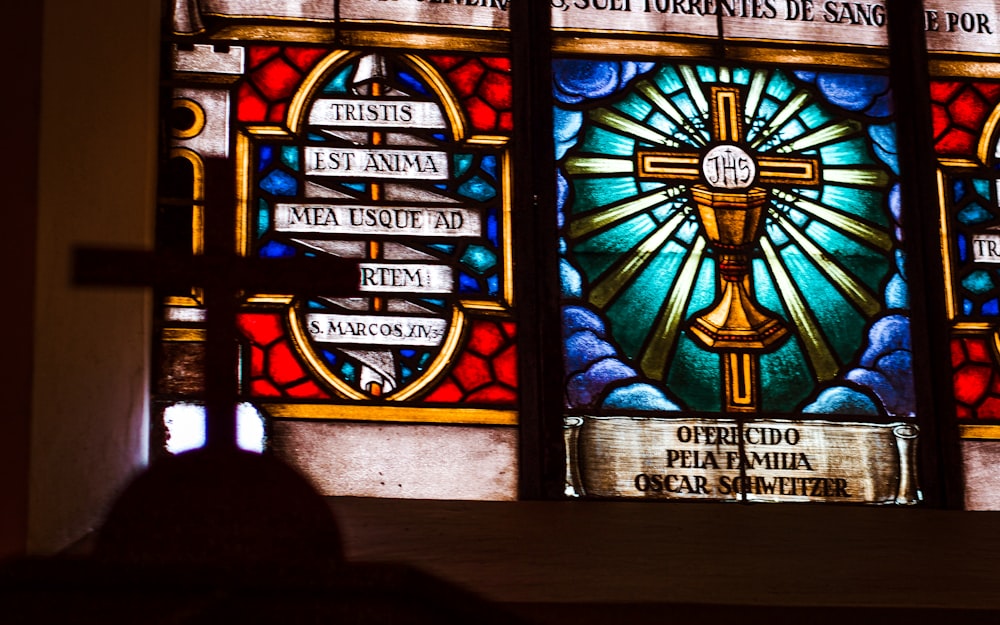 ein Buntglasfenster mit einem Kreuz darauf
