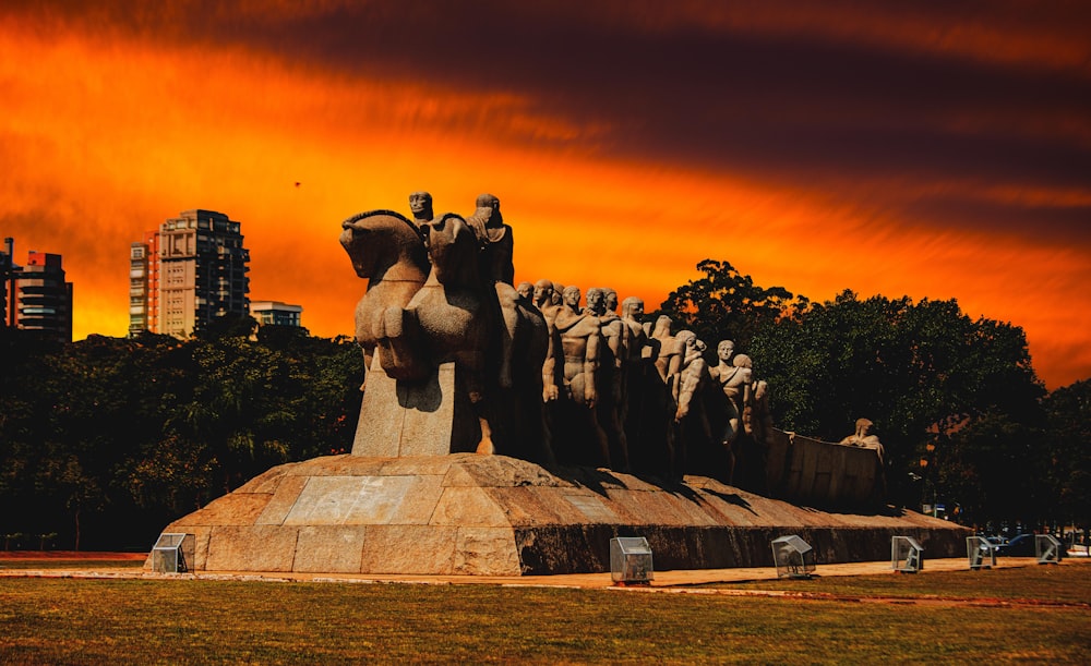 statue of people on green grass field during sunset