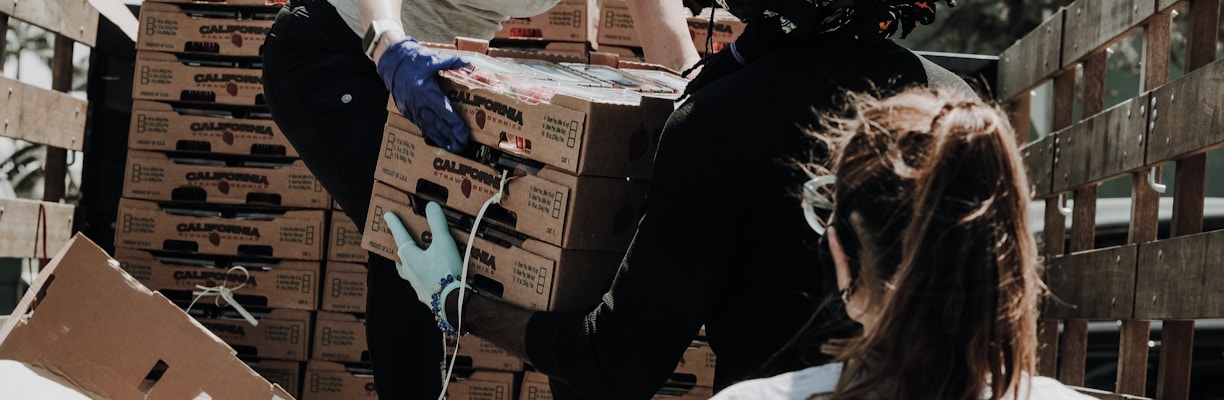 woman in white t-shirt and blue denim jeans sitting on brown cardboard box