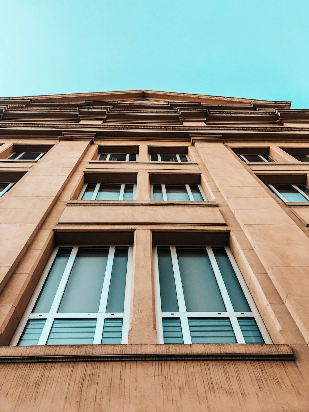 Edificio de hormigón marrón bajo el cielo azul durante el día