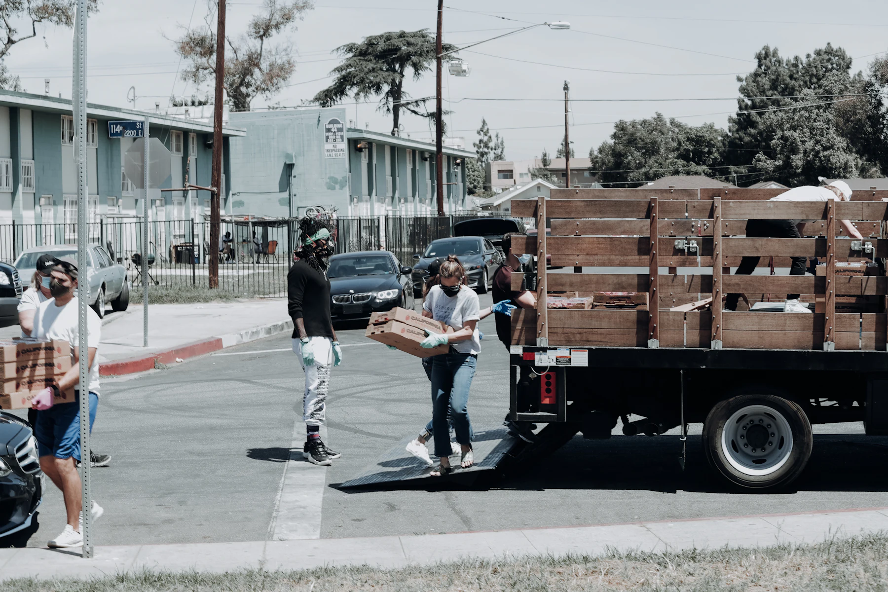 Volunteers unloading boxes of groceries from a truck at a neighborhood food distribution