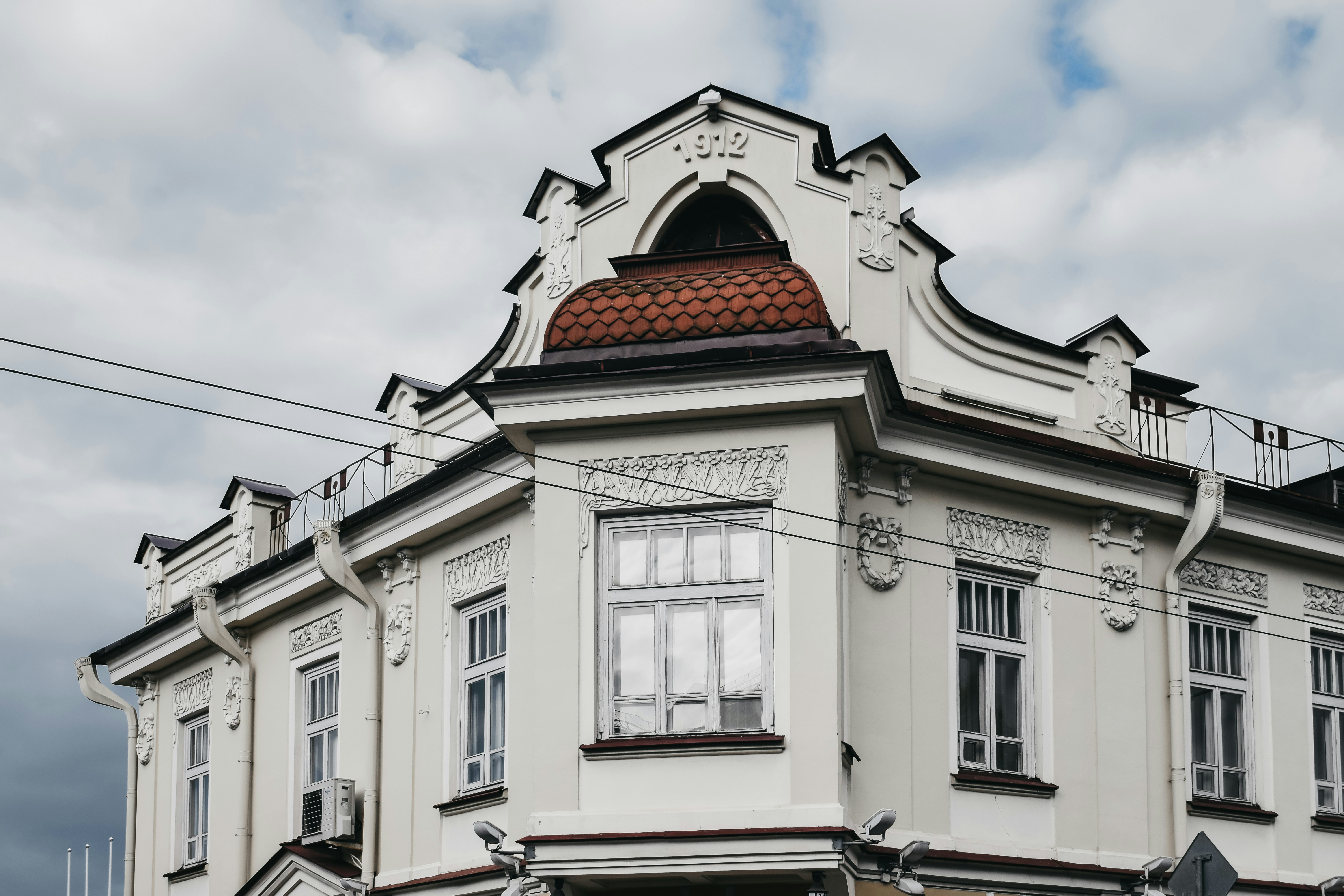 white and brown concrete building under white clouds during daytime