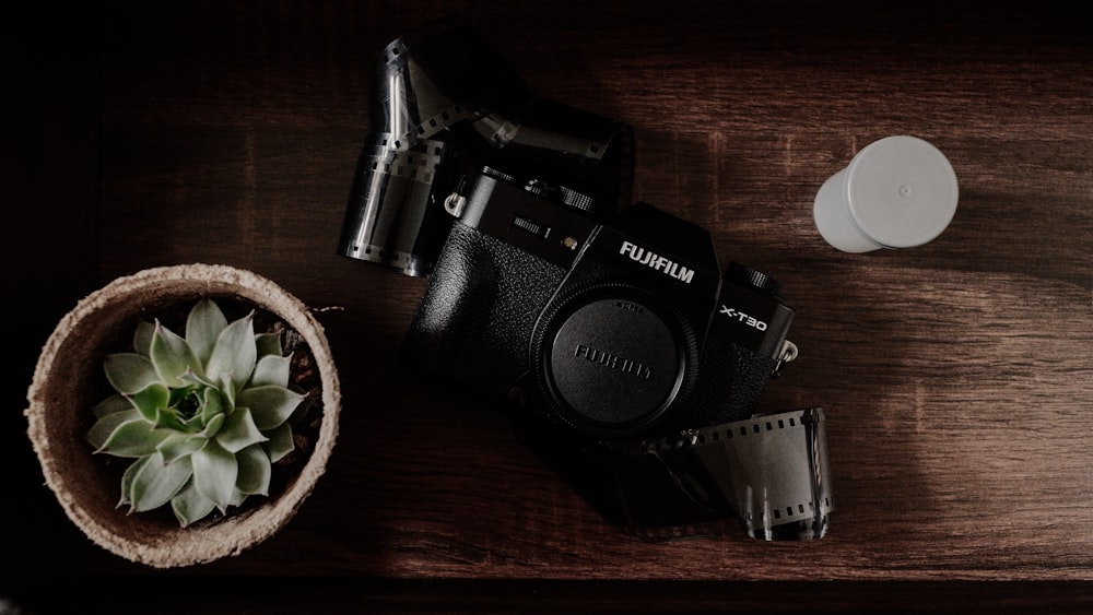 black nikon dslr camera on brown wooden table