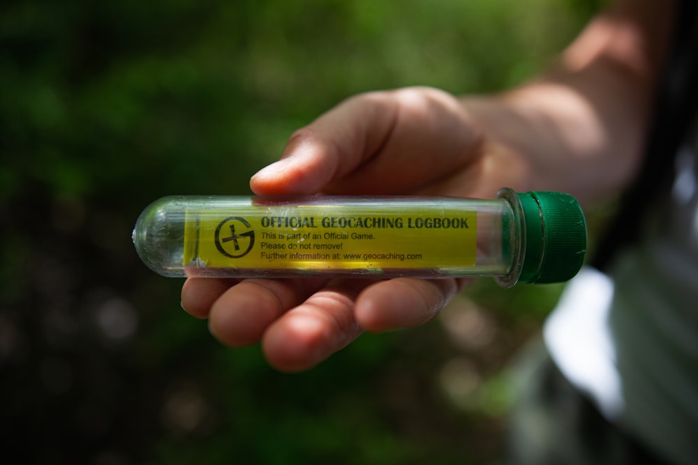 person holding yellow and green plastic bottle