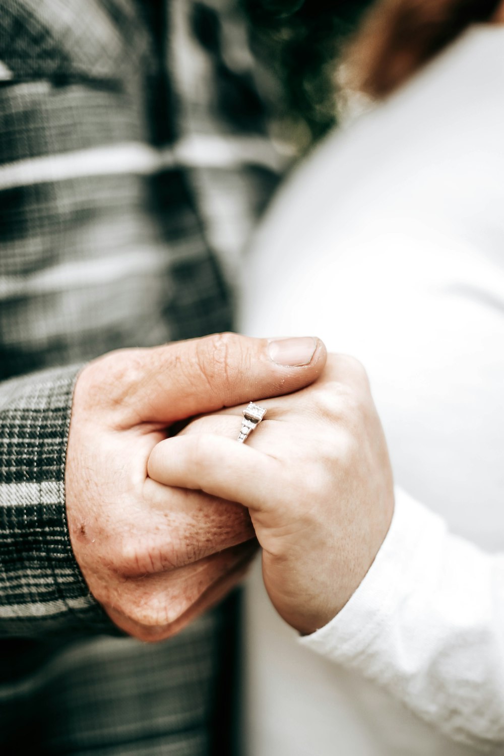 person wearing silver ring and white long sleeve shirt