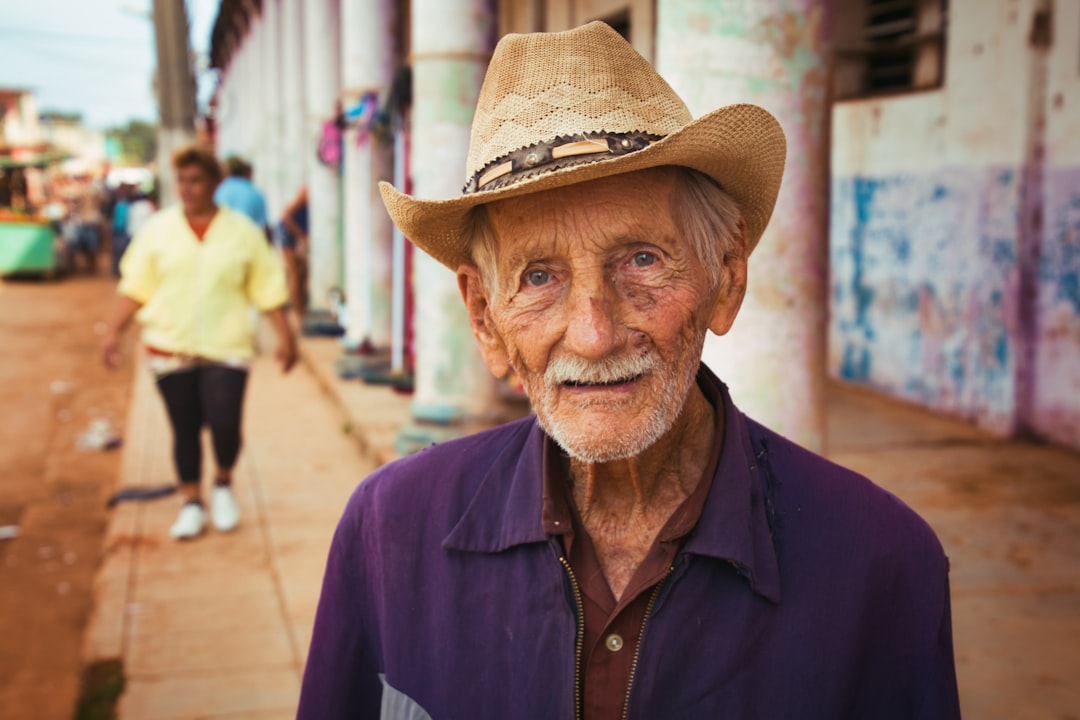 Old man with straw hat on sidewalk